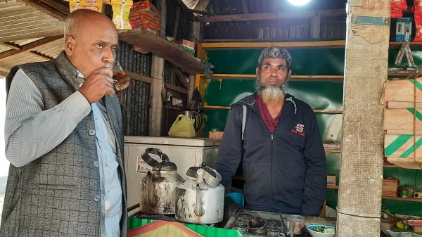 দোকানে আসা একজন বীর মুক্তিযোদ্ধাকে চা পান করাচ্ছেন আছর আলী। গত বৃহস্পতিবার টাঙ্গাইলের ধনবাড়ী উপজেলার বাজিতপুর গ্রামেছবি: প্রথম আলো